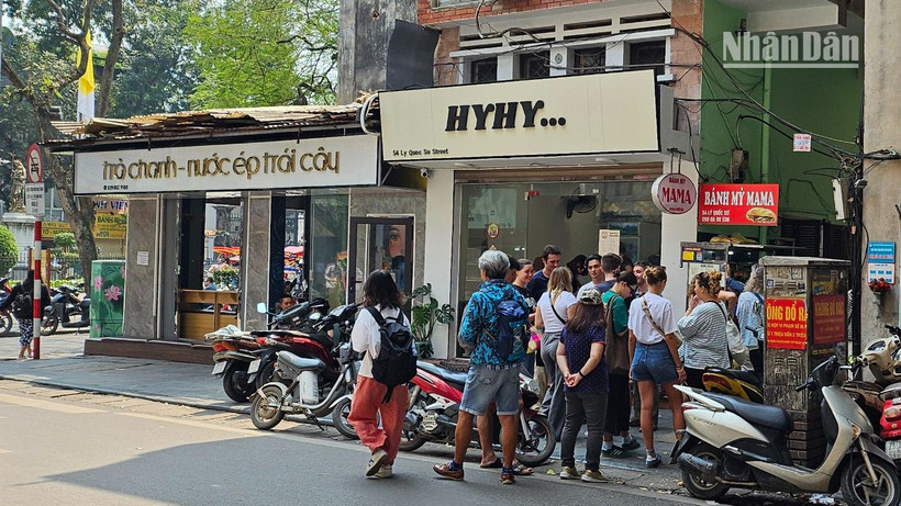 Khách du lịch nước ngoài đứng xếp hàng chờ mua bánh mì tại một cửa hàng nhỏ trên phố Lý Quốc Sư, Hà Nội.